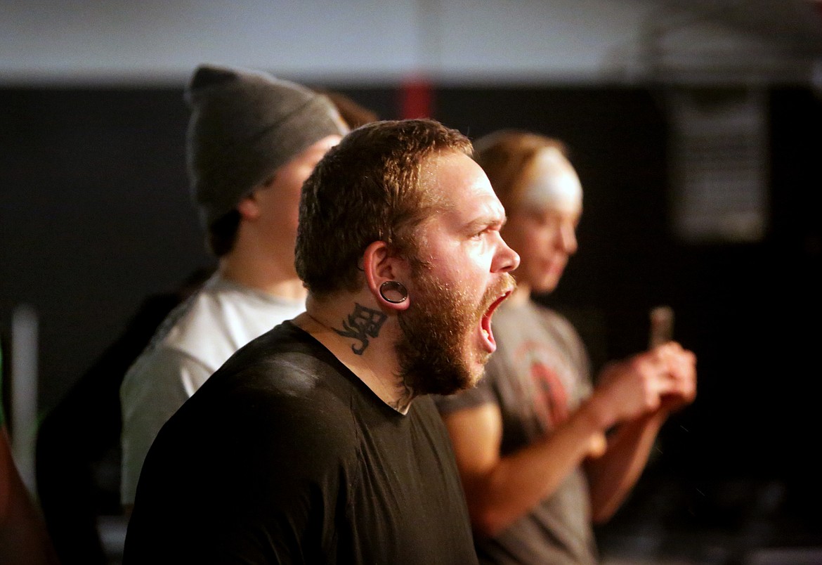 Bert Stone, 30, of Bigfork cheers on Marcus Applegate during a Thursday squat practice.