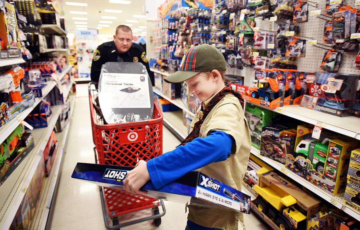 Trevor Wilson, 11, shops with Mike Johnson of the Columbia Falls Police Department during the annual Shop with a Cop program on Thursday at Target in Kalispell. The purpose of the event is to help foster positive relationships between children and police officers.