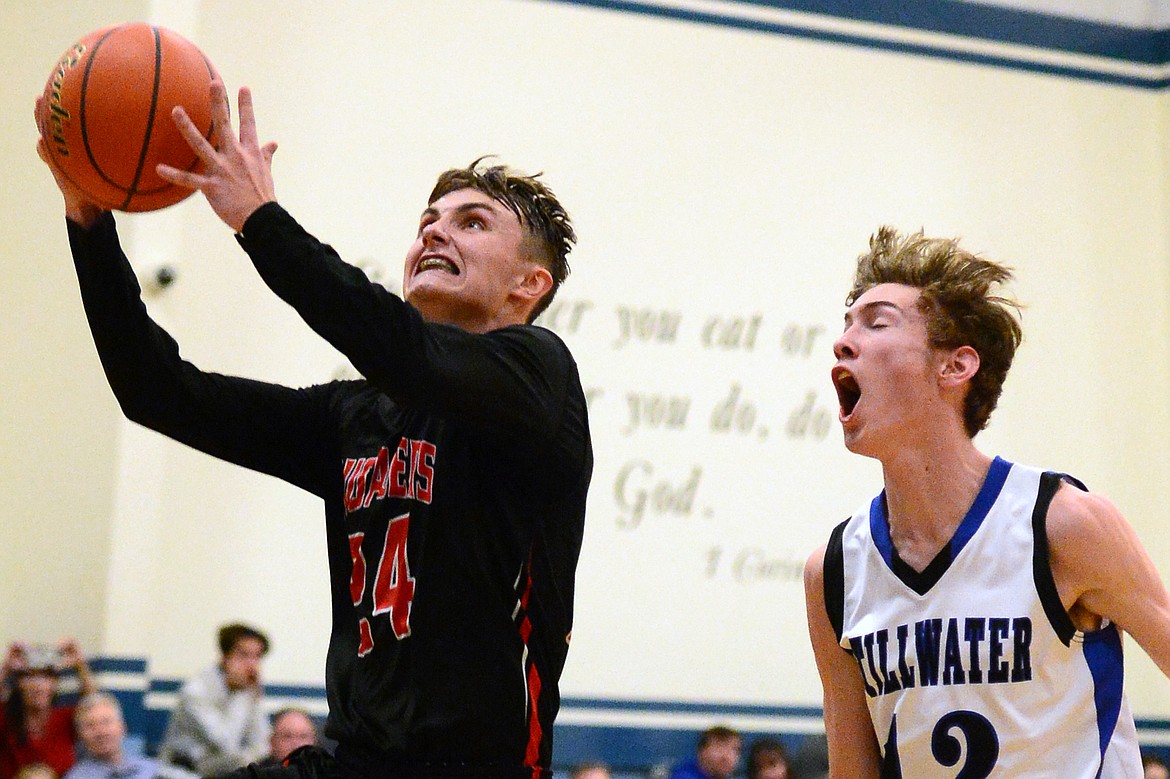 Flathead Valley Homeschool's Spencer Burden drives to the hoop with Stillwater Christian defender Nicholas Sulzbacher trailing. (Casey Kreider/Daily Inter Lake)