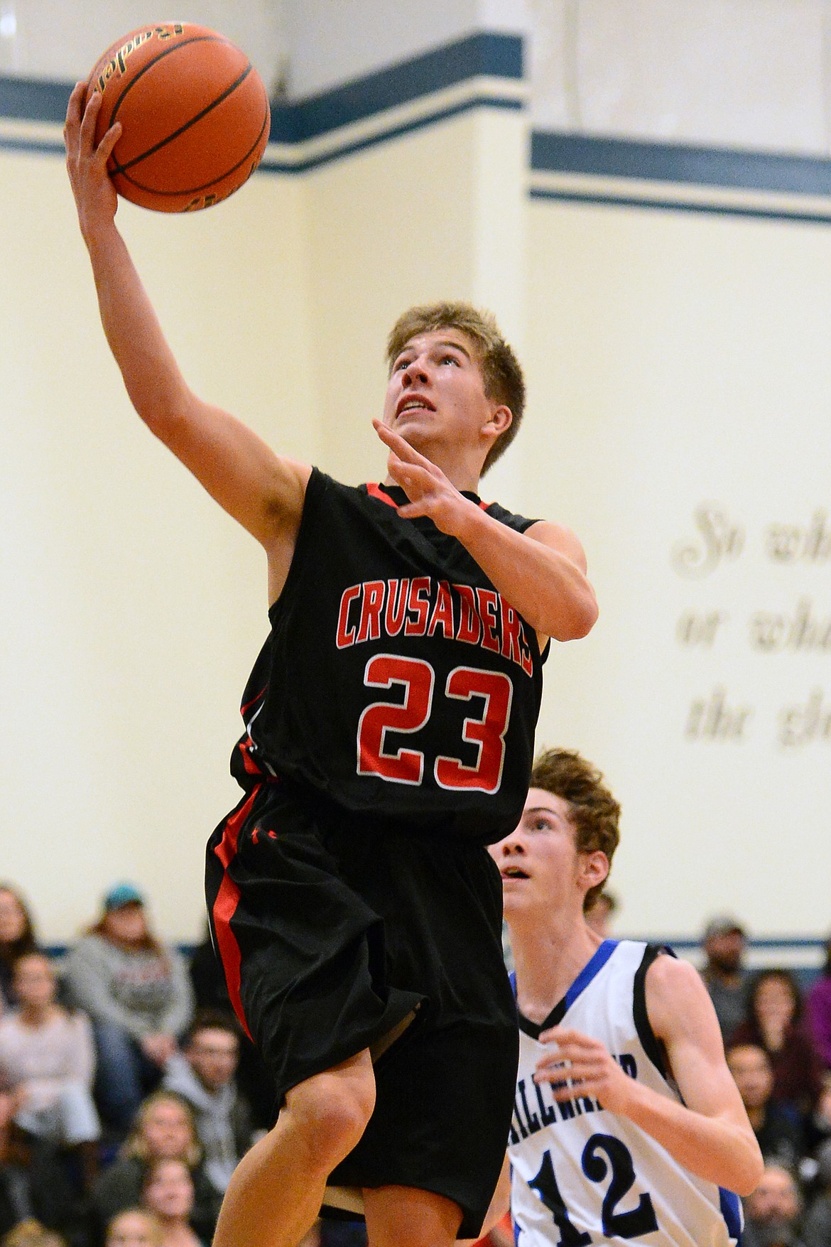 Flathead Valley Homeschool's Jordan Wininger lays in two points with Stillwater Christian defender Nicholas Sulzbacher trailing. (Casey Kreider/Daily Inter Lake)