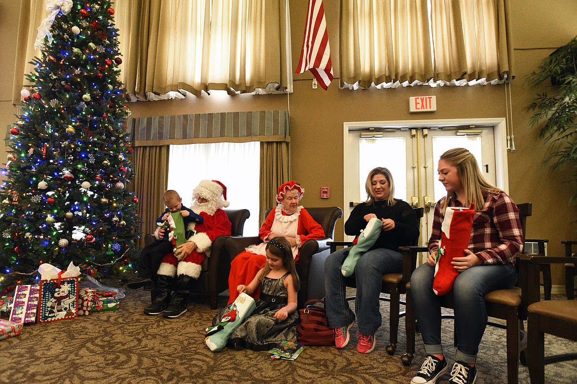 The Jaeger family opens gifts purchased by the residents at Prestige Assisted Living in Kalispell on Wednesday, Dec. 13. (Casey Kreider/Daily Inter Lake)