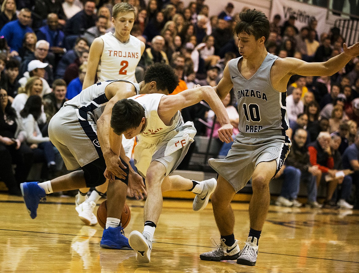 LOREN BENOIT/Press
Drake Thompson of Post Falls loses the ball as he drives into the Gonzaga Prep defense Thursday night at Post Falls High School.