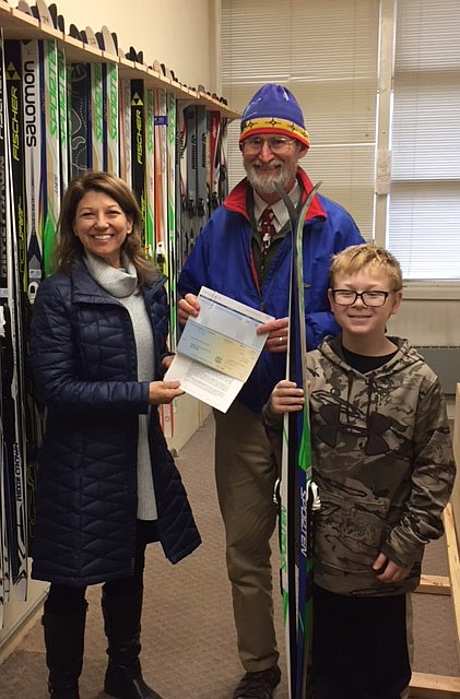 Gwenn Hensler of the Lincoln County Community Foundation presents a check to Greg Rice, president of the Kootenai Cross Country Ski Club, for the purchase of ski gear for the after-school ski program. Pictured also is student skier Cael Schwindt. (Courtesy photo)