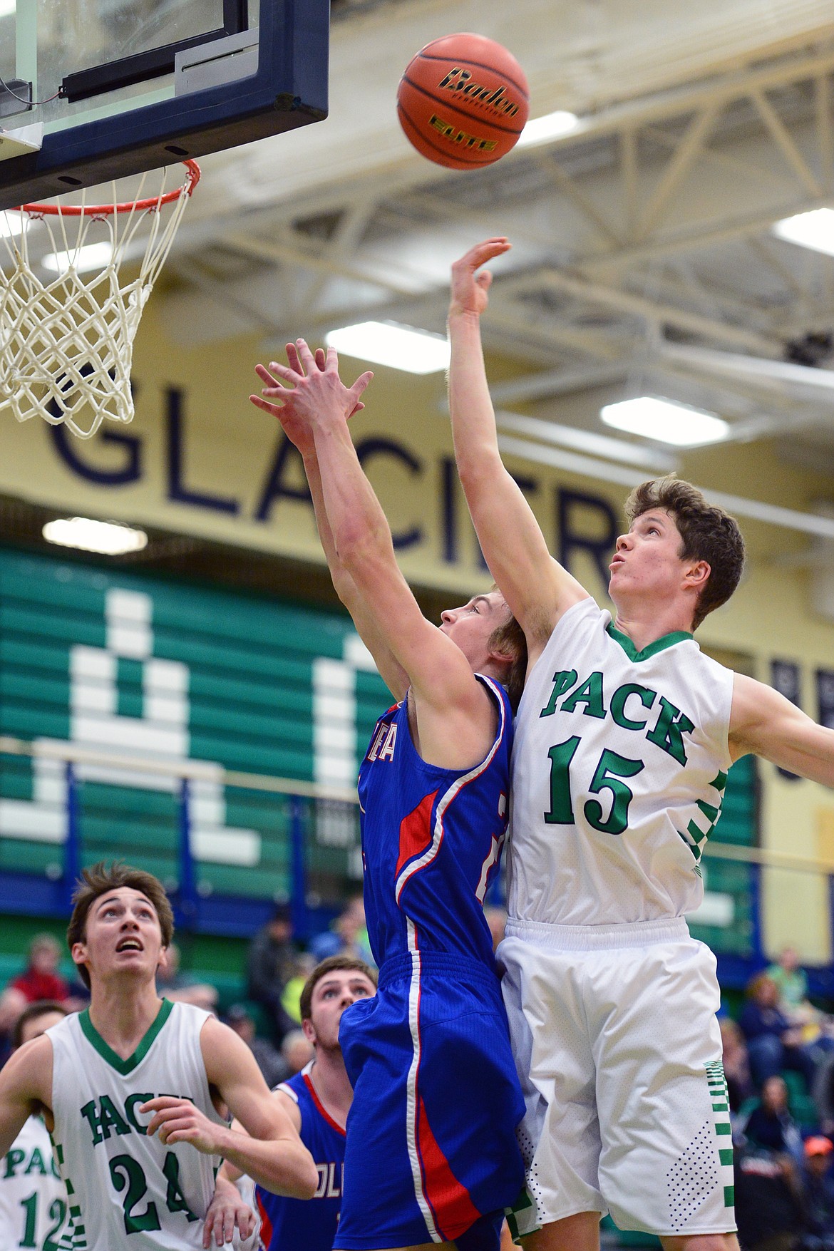 Glacier&#146;s Drew Engellant tips a rebound over Columbia Falls&#146; Logan Bechtel. (Casey Kreider/Daily Inter Lake)