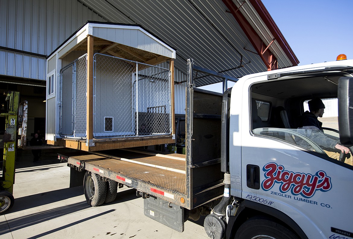 LOREN BENOIT/Press
Parker Williams, with Ziggy's, helps load a dog house for Post Falls Police Department's newest K9. The house was unveiled Friday morning at Kootenai Technical Education Campus, where 23 students spent about 20 hours building it in just four days.