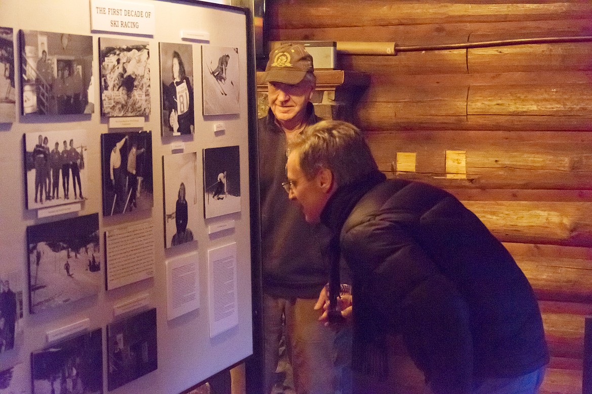 Flathead Valley Ski Education Foundation Director Tim Hinderman looks on as people examine historic photographs during an open house event Thursday at the Ski Heritage Center Museum of Skiing.