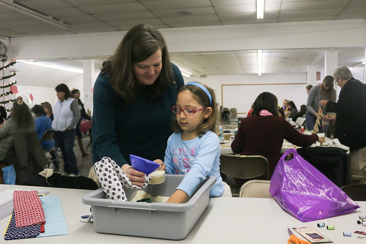 Photo by Mandi Bateman
Eight year old Eva Naranjo works on filling a rice bag.