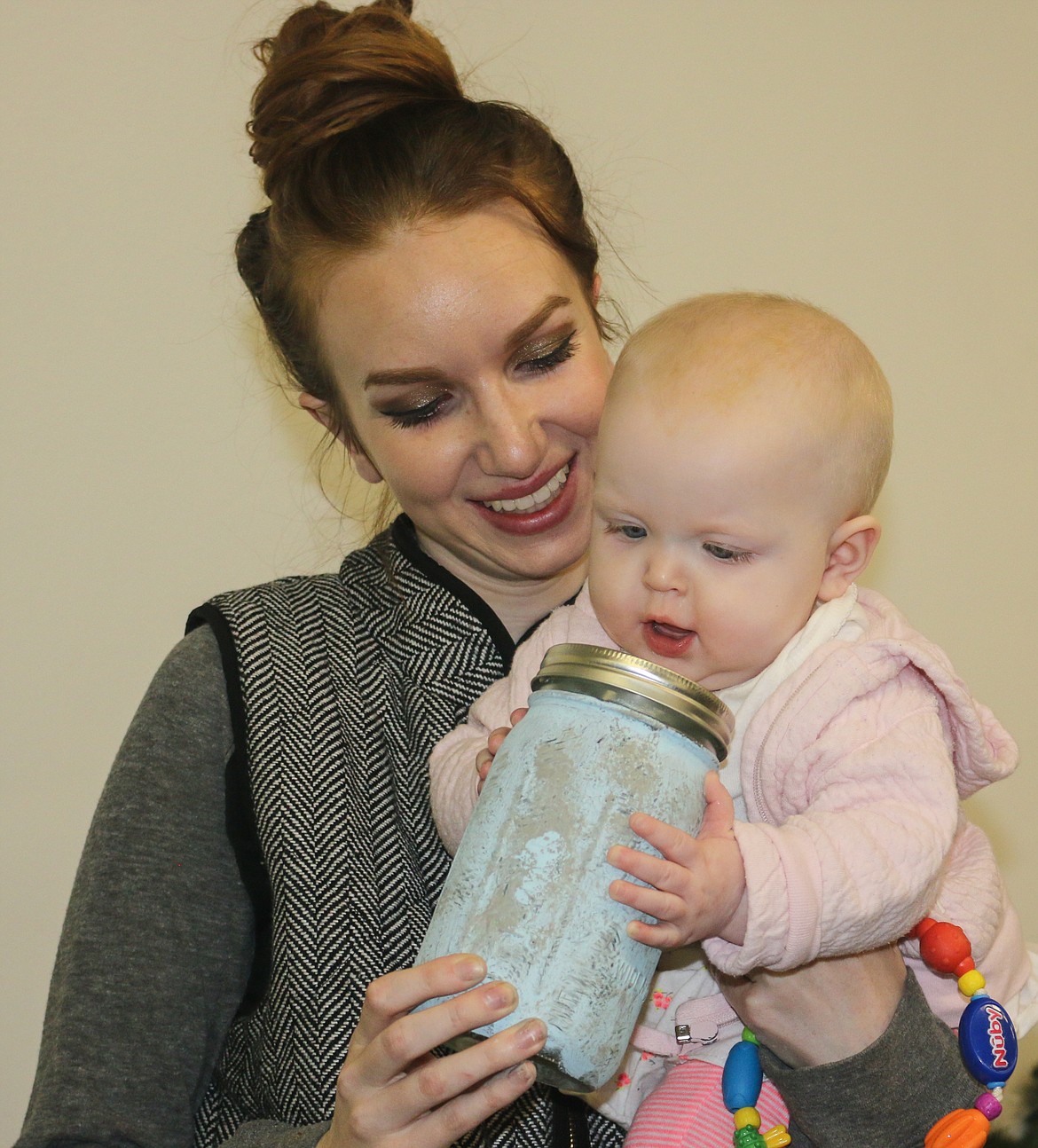 Photo by Mandi Bateman
Savannah Symonds with her baby, Elizabeth, and a tissue jar crafting project.