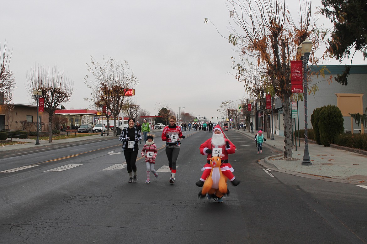 Joel Martin/Columbia Basin Herald
Runners &#8211; including Santa on an overburdened reindeer &#8211; make their way up Basin Street in the 3-mile fun run during Ephrata&#146;s Miracle on Main Street celebration Saturday.