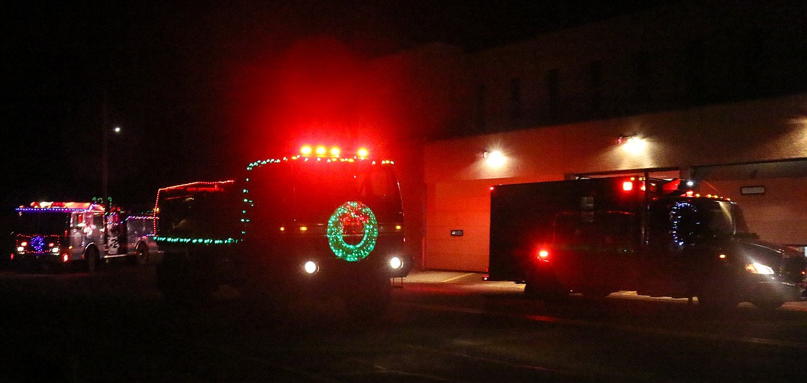 Two firetrucks and an ambulance arriving at the City Fire department during the Chariots of Fire parade.