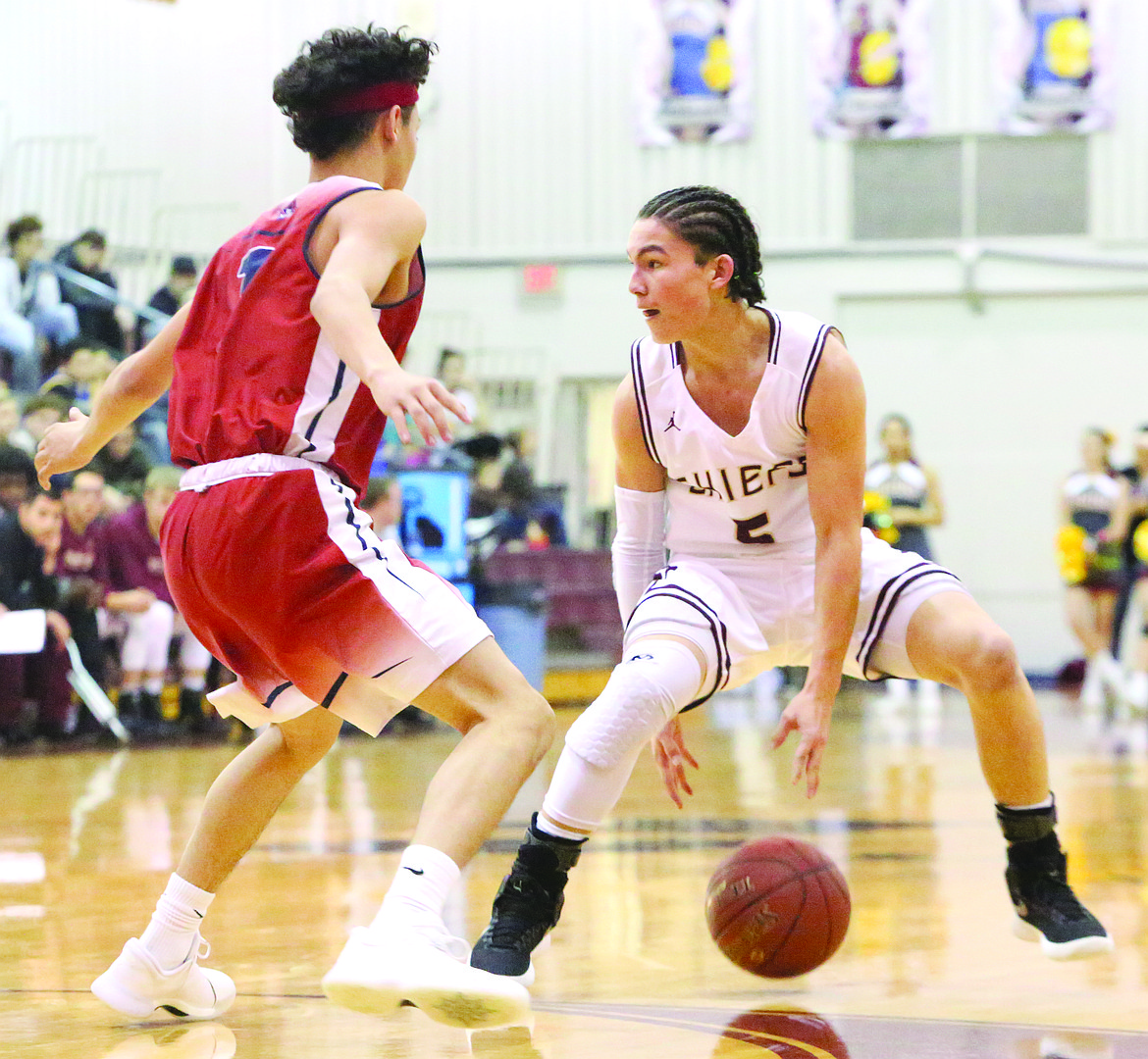 Connor Vanderweyst/Columbia Basin Herald
Moses Lake point guard Cory Kunjara dribbles between his legs against Eisenhower.