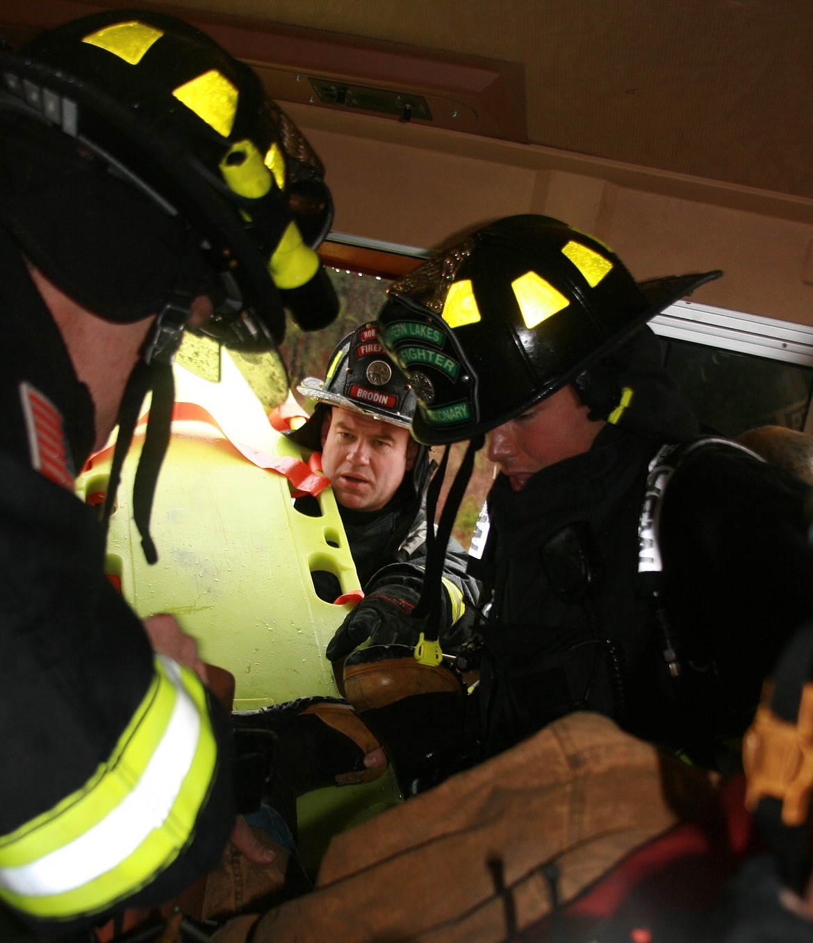 From left, Northern Lakes Firefighter /Medic Aaron O&#146;Brien, Firefighter Justin Brodin and Firefighter Garrett Kitterman work to rescue a &#147;patient&#148; in the tight quarters and out the window of a BNSF Railway locomotive. (BRIAN WALKER/Press)