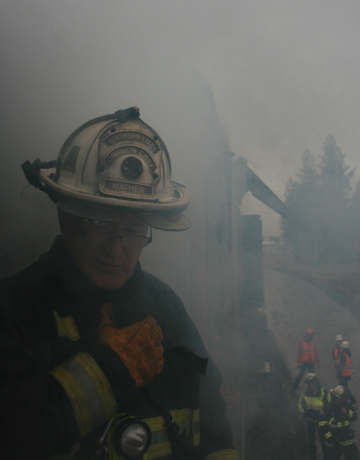 Northern Lakes Fire District Division Chief Mike Mather communicates with other rescuers below during locomotive training as simulated smoke pours out of the engine. (BRIAN WALKER/Press)