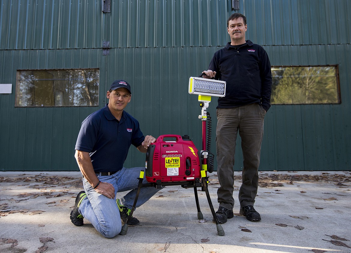 Ventry salesman Chris Nelson, left, and CEO James Neils pose with a Lentry Light outside of their Hauser Lake shop. The portable light towers range from $2,500 to $9,500. They put out as much power as a unit that&#146;s towed to construction sites and cost less than half the price.