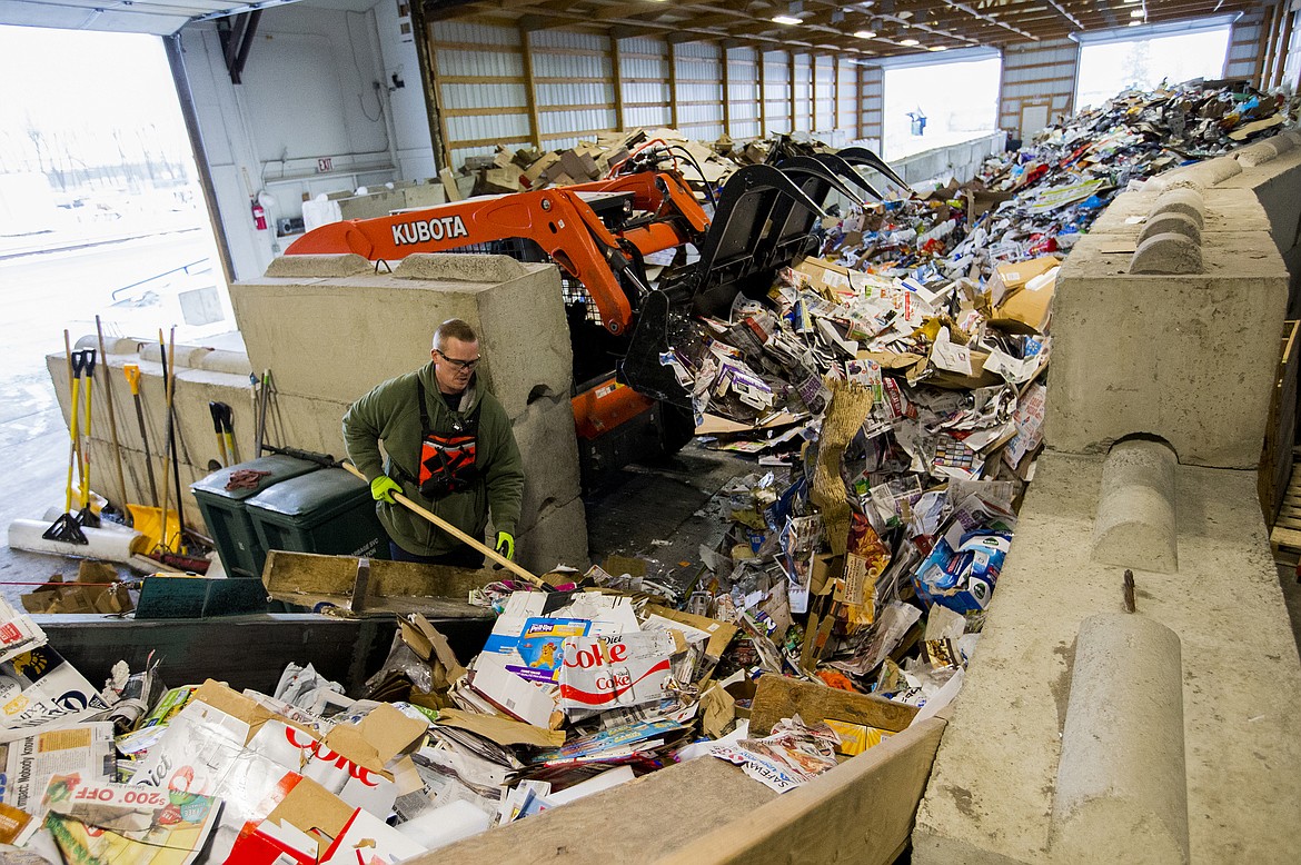 Employee Kyle Scott helps move over garbage to the compactor Friday afternoon at Coeur d'Alene Garbage. (LOREN BENOIT/Press)