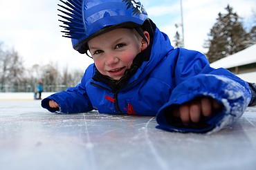 Jackson Hiland gets a close look at the ice at Woodland Park during Kalispell Parks and Recreation Freeze Out Camp on Tuesday. (Casey Kreider/Daily Inter Lake)