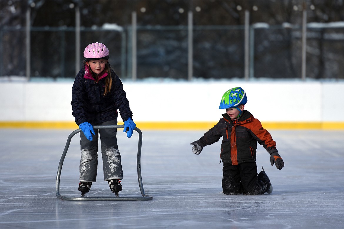 Hannah Brabham, left, uses an ice skating trainer while Gage Counts looks on at Woodland Park during Kalispell Parks and Recreation Freeze Out Camp on Tuesday. (Casey Kreider/Daily Inter Lake)