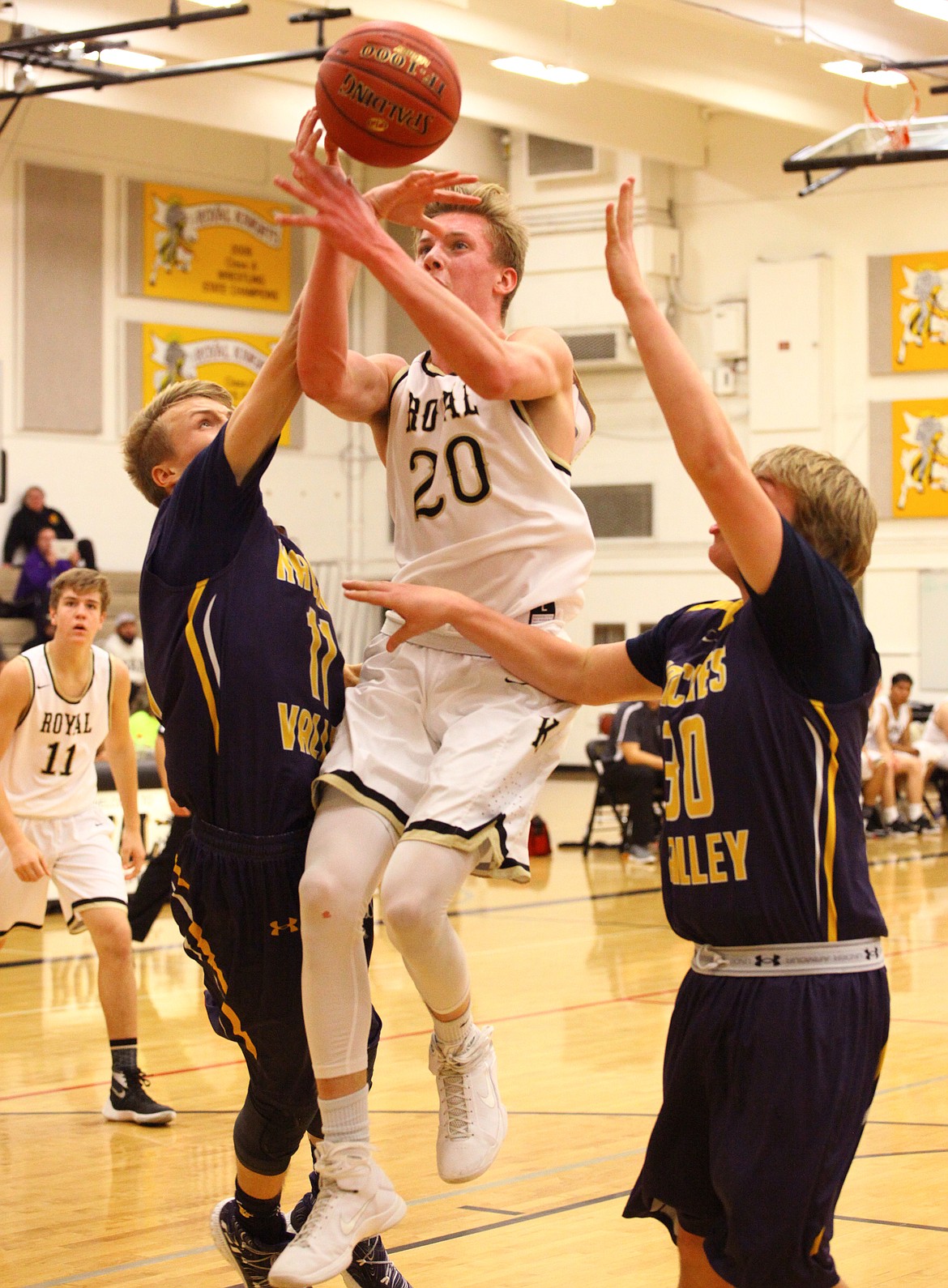 Rodney Harwood/Columbia Basin HeraldRoyal guard Corbin Christensen is fouled by Jarrett Simmons (11) of Naches Valley during the first half of Friday night's SCAC game.