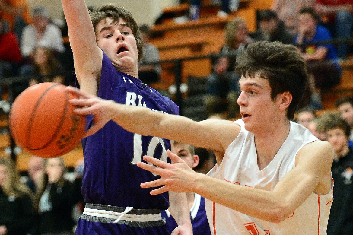 Flathead&#146;s Tyler Johnson passes along the baseline in front of Butte defender Kale McCarthy. (Casey Kreider/Daily Inter Lake)