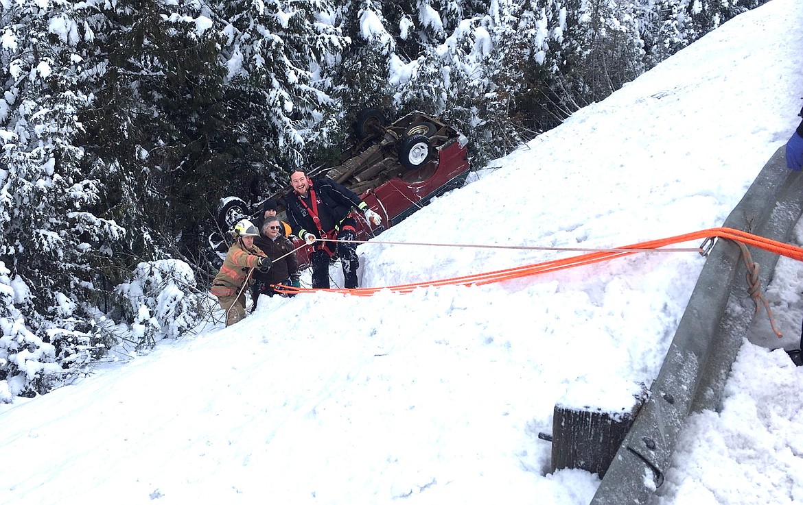 Courtesy photos
The driver of a car which rolled down an embankment near U.S. 95 mile marker 501 on Peterson Hill is helped back to the road on Wednesday morning.