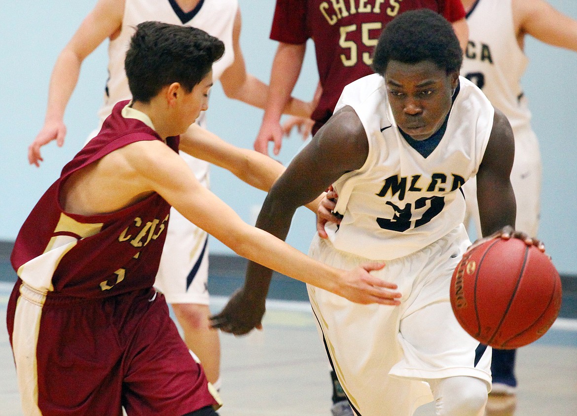 Rodney Harwood/Columbia Basin Herald
Moses Lake Christian point guard Pierre Boorman (32) pushes the ball up the floor against Dylan Roylance (5) of the Moses Lake freshmen team in non-league action Thursday night.