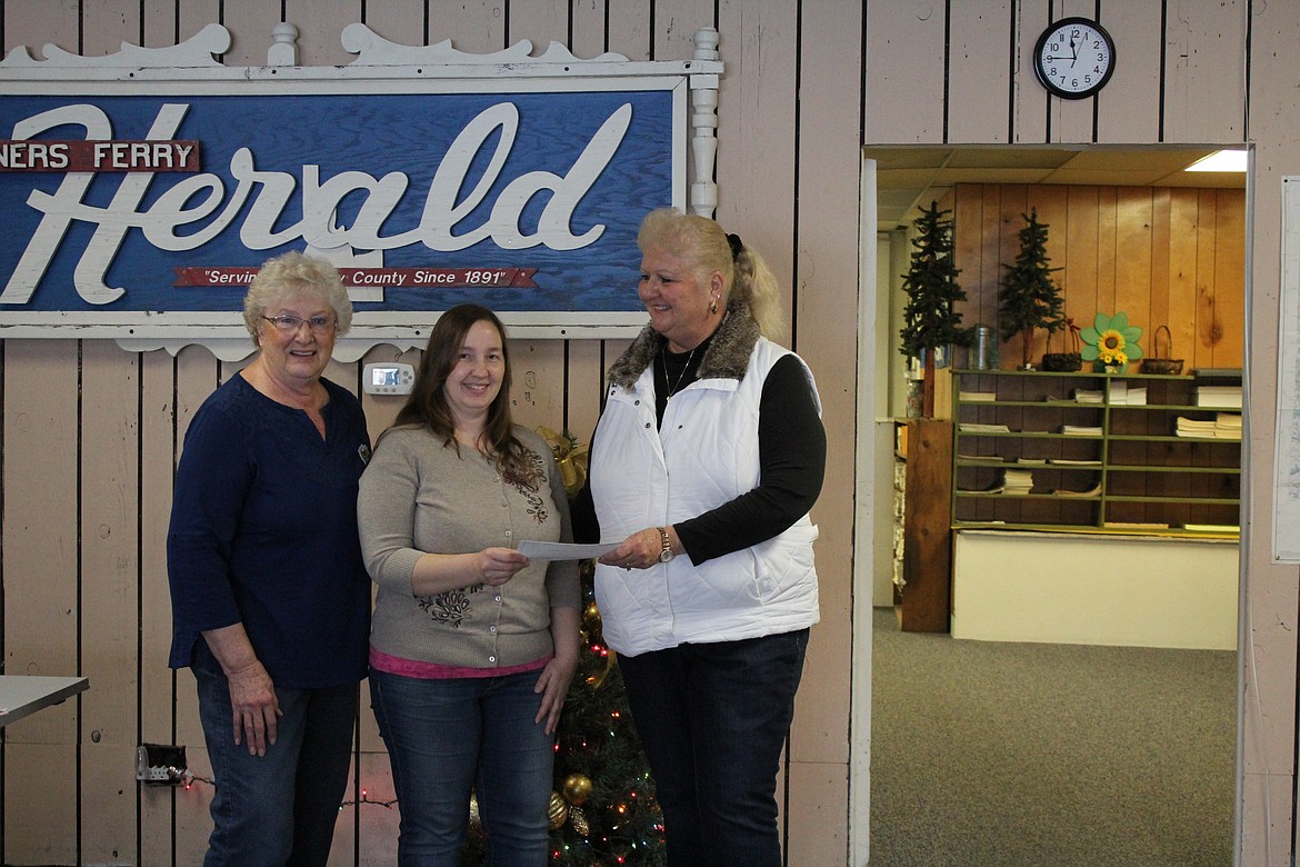 Photo by Tanna Yeoumans
Debora Perry, right, hands Tanya Currie her P.E.O. Program for Continuing Education grant award as Currie&#146;s fifth grade teacher and chapter Chairman, Dottie Grey, stands by proudly.