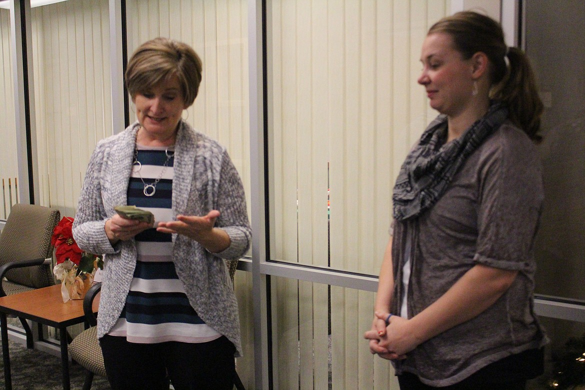 Cheryl Schweizer/Columbia Basin Herald
Sheila Chilson (left) of the Grant County Homeless Task Force received a donation of cash from a charitable raffle earlier this week. The raffle was the inspiration of Columbia Basin Herald marketing consultant Ashley Hoffer (right).