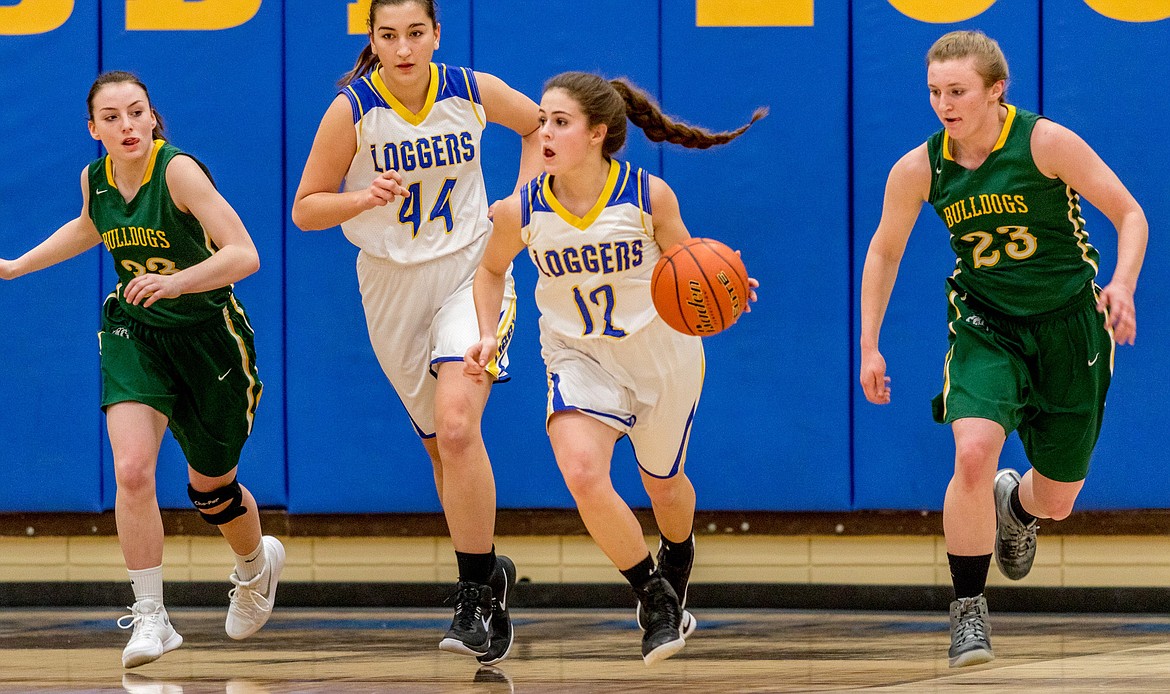 Libby's Alli Collins heads down court flanked by teammate Brooklyn Rainer and Payton Kastella, left, and Annisa Brown of Whitefish Thursday in Libby. (John Blodgett/The Western News)