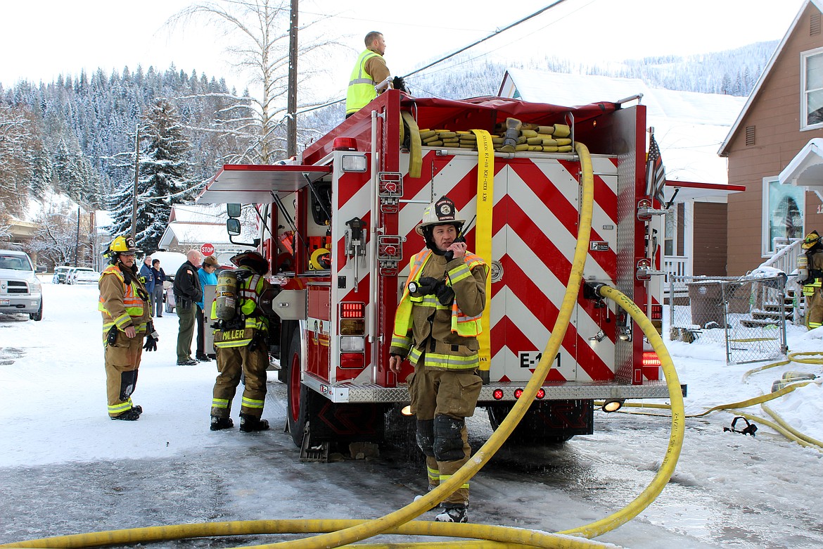 Chief Aaron Cagle directs crews to their positions over the radio while firefighters prepare to spring into action.