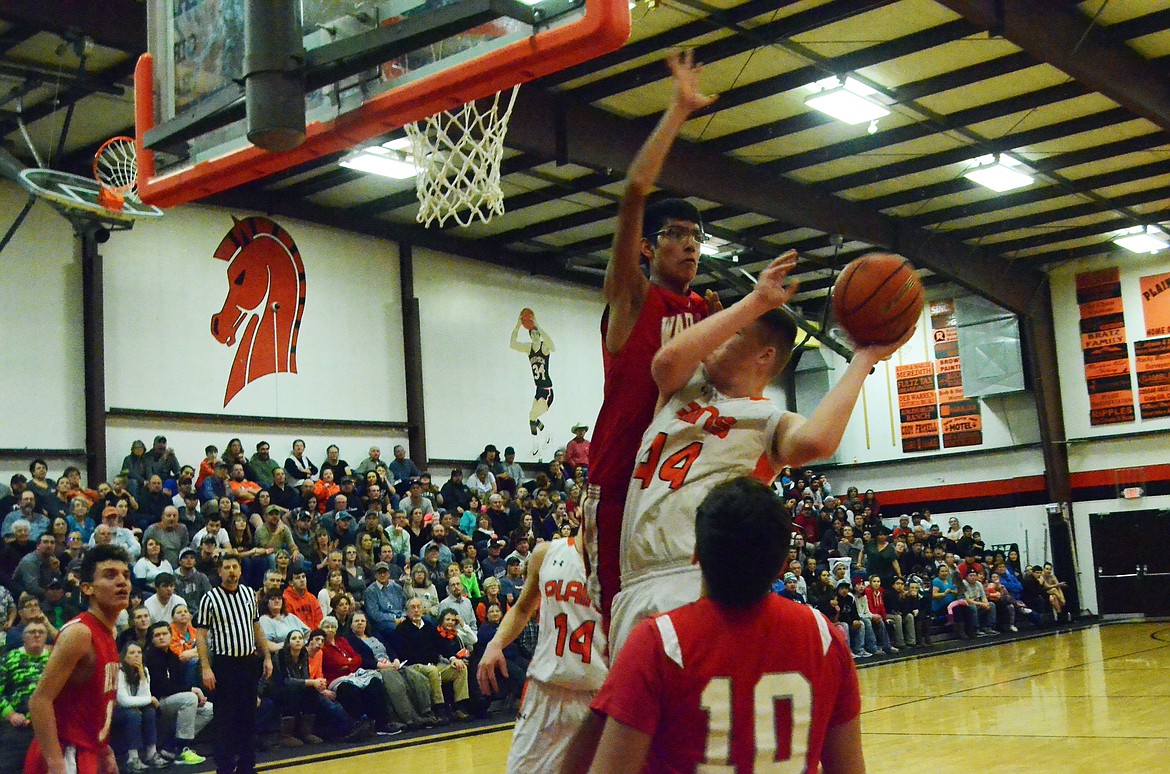 Not even Warrior Isaac Fisher(33) who stands at 6&#146;8&#148; could stop Derick Curry (44) from making a basket for the Horsemen (Erin Jusseaume/ Clark Fork Valley Press)