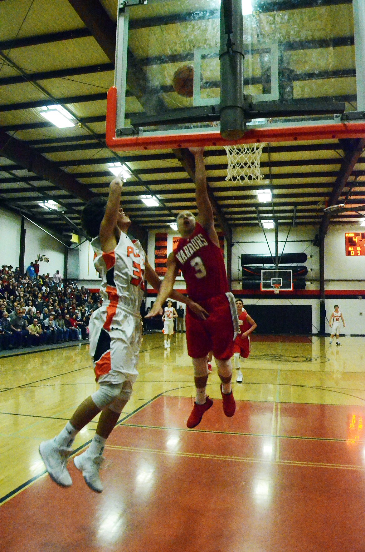 Sinjin Ladeaux (32) goes for the basket while Warrior Will Mesteth makes a last block attempt (Erin Jusseaume/ Clark Fork Valley Press)