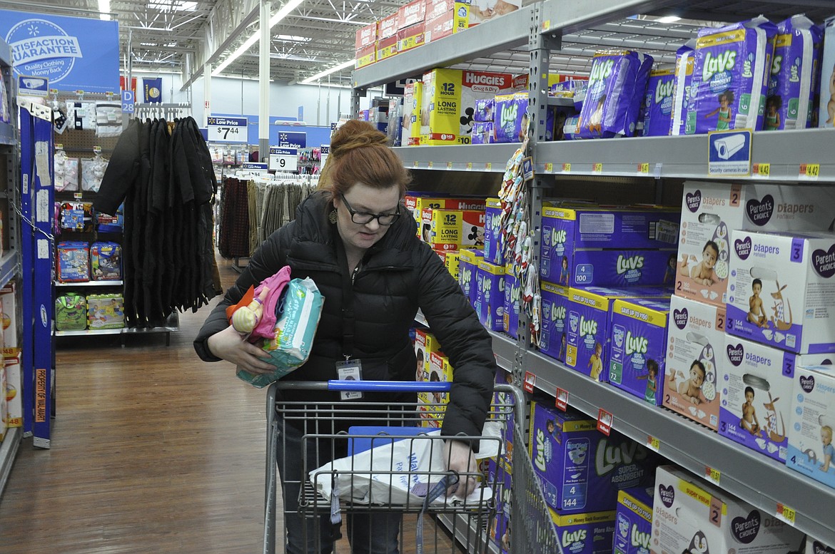 Dorothy Gilmore, a clerk with the Lake County Sheriff&#146;s Office, checks a Christmas list Friday. Gilmore participated in Share the Spirit, gathering items purchased by funds raised by the Deputies Association. (Ashley Fox/Lake County Leader)