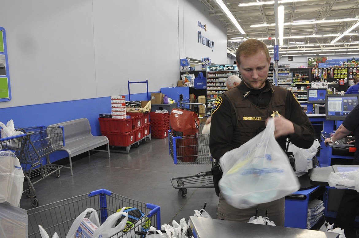 Lake County Sheriff&#146;s Office Deputy Clay Shoemaker bags items purchased for Share the Spirit. (Ashley Fox/Lake County Leader)