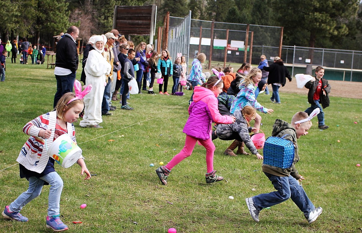 Annual Easter Egg Hunt Warms Chilly Morning in St. Regis for Dozens of Kids, April 19: Brooklyn, 8, (left), Madison Downing (middle), and Kody Crane (right) race to get eggs and candy. (Kathleen Woodford/Mineral Independent).