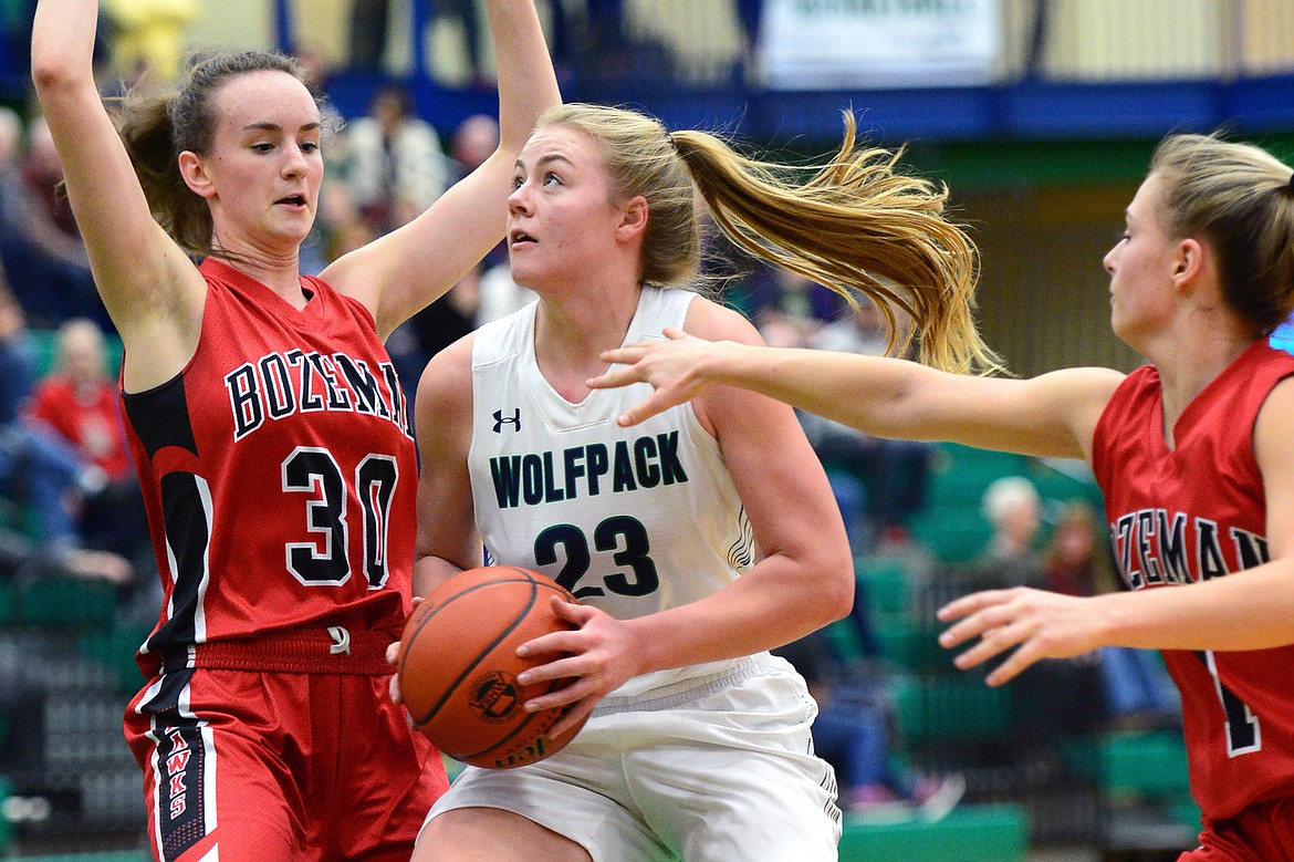 Glacier's Anna Schrade drives to the hoop with Bozeman's Alex Carey (30) and Ayla Embry (1) defending. (Casey Kreider/Daily Inter Lake)