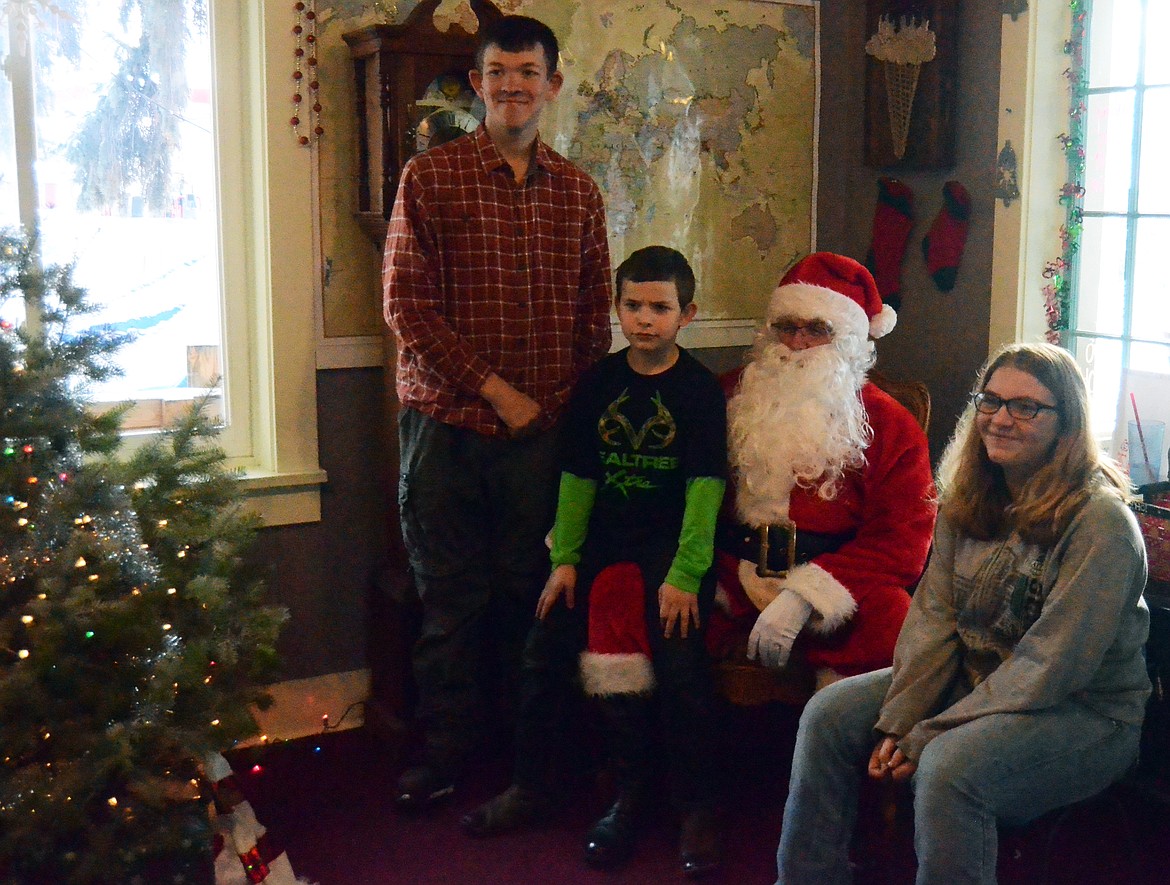 Beau, Izzy and Damien Crabb pose for a photo with Santa (Erin Jusseaume/ Clark Fork Valley Press)