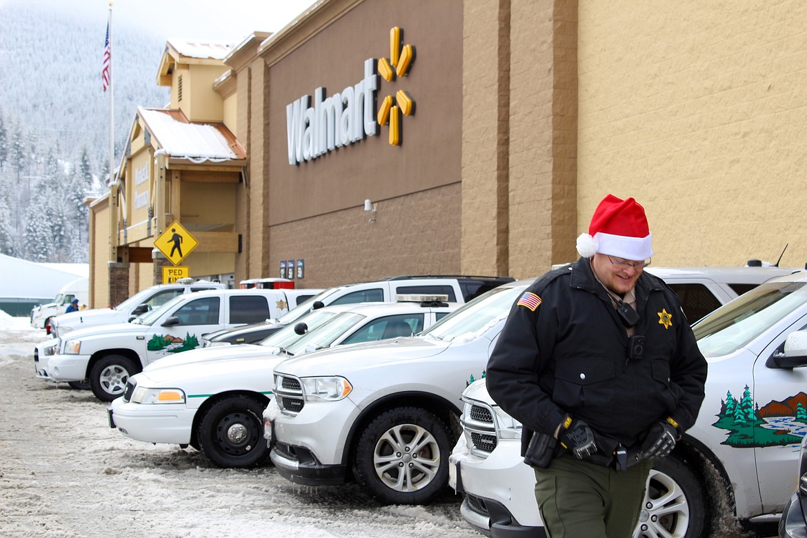 Photo by CHANSE WATSON
SCSO deputy Darius Dustin keeps watch on the patrol vehicles parked outside while everyone gets their shopping in.