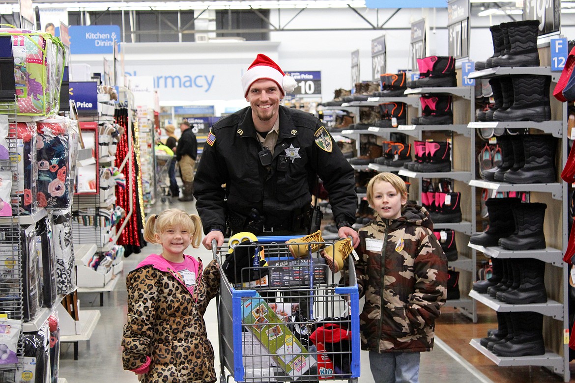 Photo by CHANSE WATSON
SCSO Sgt. Jared Bilaski and his assigned children smile for the camera near the shoes section.