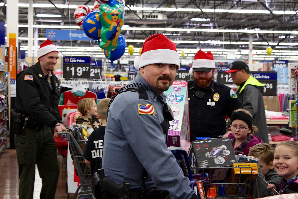 Photo by CHANSE WATSON
(Left) Deputy Bilaski, Pinehurst deputy Patrick Rowe, and KPD officer Kyle Hudson gather children and items for checkout.