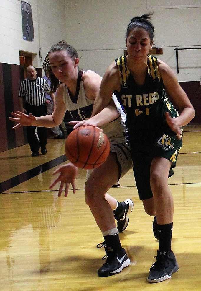 Clark Fork Mountain Cat Montanna Baughman battles over the ball with St. Regis&#146; Justice Tate during a cross-county game on Dec. 15 in Alberton. The Cats won 53-22. (Kathleen Woodford/Mineral Independent).
