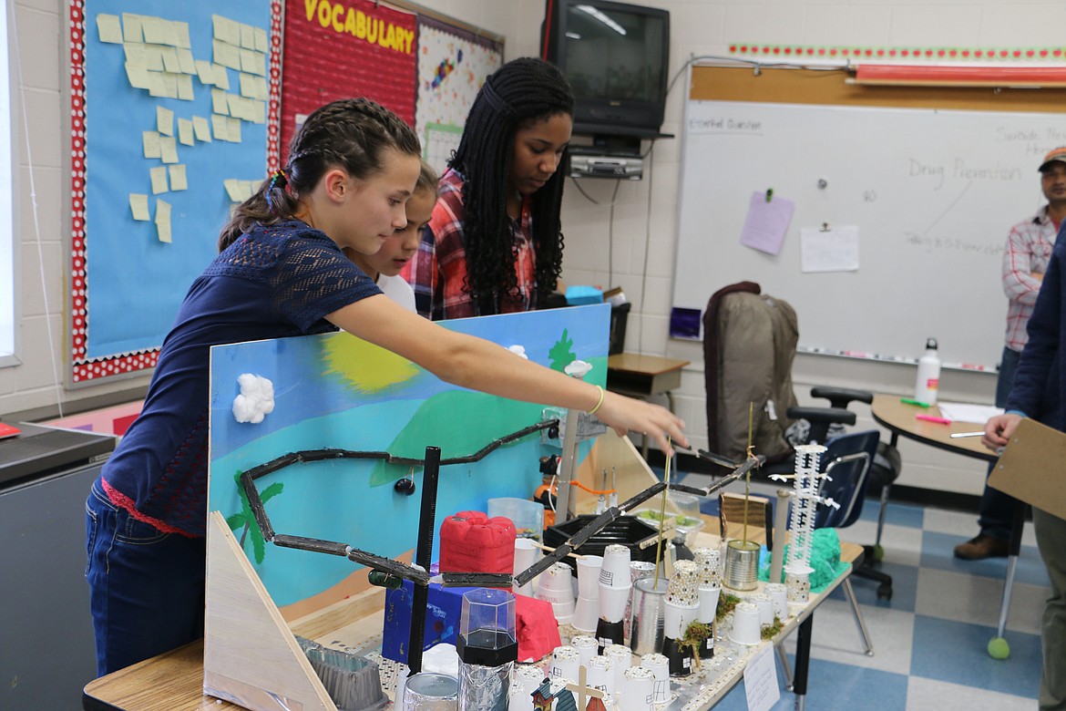 (Photo by MARY MALONE)
Washington Elementary sixth-graders, from left, Aliya Strock, Hannah Harvey and Shade Gbajumo show off the different features of their Future City project for a panel of judges on Friday.