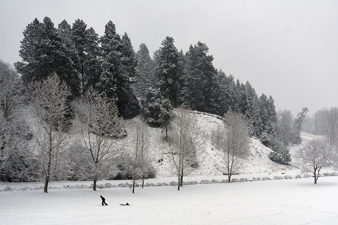 Judy Baker, of Kalispell, pulls her son Atticus, 3, to the top of the hill at Lawrence Park on Tuesday, Dec. 19. (Casey Kreider/Daily Inter Lake)