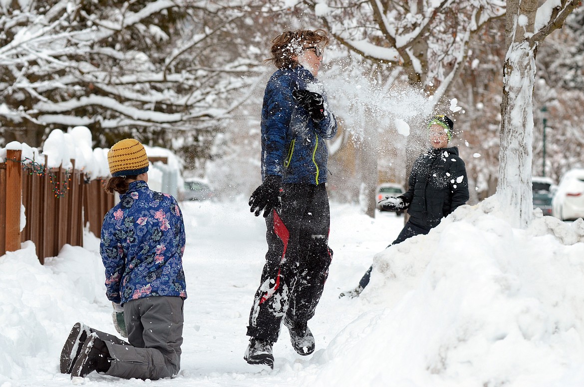 Deneb Linton, center, is hit with a snowball during a friendly snowball fight with Signe Ebbett, left, and Felix Ebbett, right, in Whitefish on Wednesday. Schools in Whitefish, Columbia Falls and West Glacier were canceled Wednesday after a snowstorm hit the area. (Matt Baldwin/Daily Inter Lake)