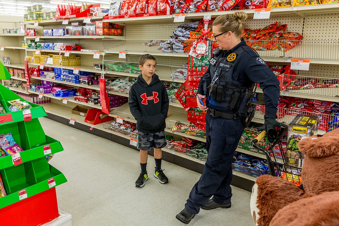 Riley Orsborn, 10, of Troy talks with Troy Police Chief Katie Davis at Shopko in Libby during Shop With a Cop Tuesday, Dec. 19, 2017. (John Blodgett/The Western News)