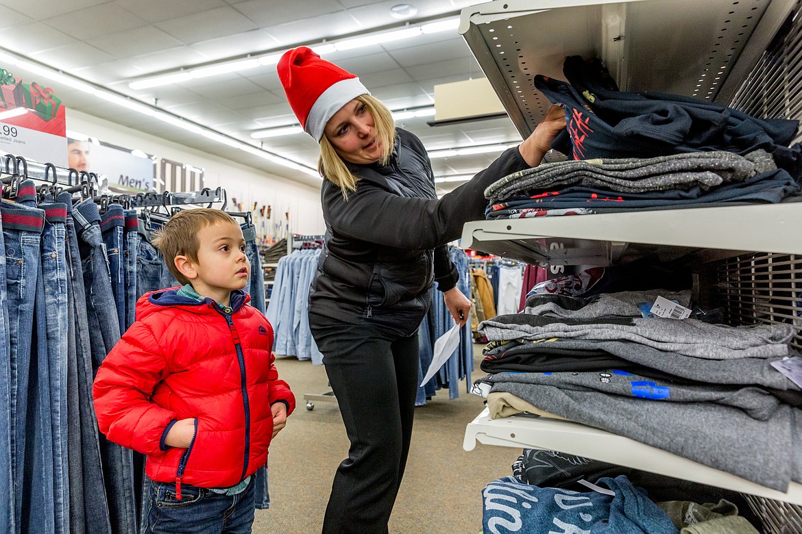 Kaide Dodson, assistant principal at Libby Middle/High School, helps Bentley Seefeldt, 5, find a t-shirt for his grandfather at Shopko in Libby during Shop With a Cop Tuesday, Dec. 19, 2017. Dodson&#146;s husband, Lincoln County Sheriff&#146;s Deputy Brad Dodson, organized the annual event. (John Blodgett/The Western News)