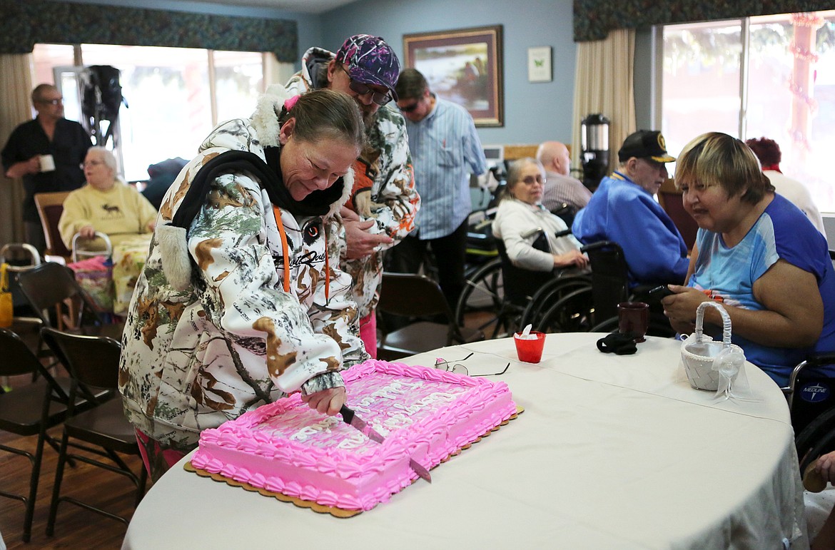 Denise Worthington-Sisco cuts her wedding cake with husband, Todd, by her side at Lake View Care Center in Bigfork Sunday morning. (Mackenzie Reiss/Daily Inter Lake)