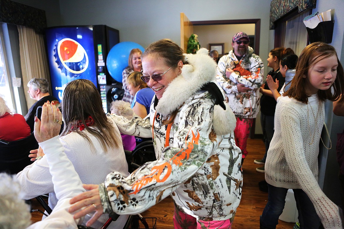 Denise Worthington-Sisco greets residents at Lake View Care Center in Bigofrk after her wedding ceremony at the center. Worthington-Sisco wed Todd Sisco outside the facility and residents lined up near large windows to watch it all unfold. (Mackenzie Reiss/Daily Inter Lake)