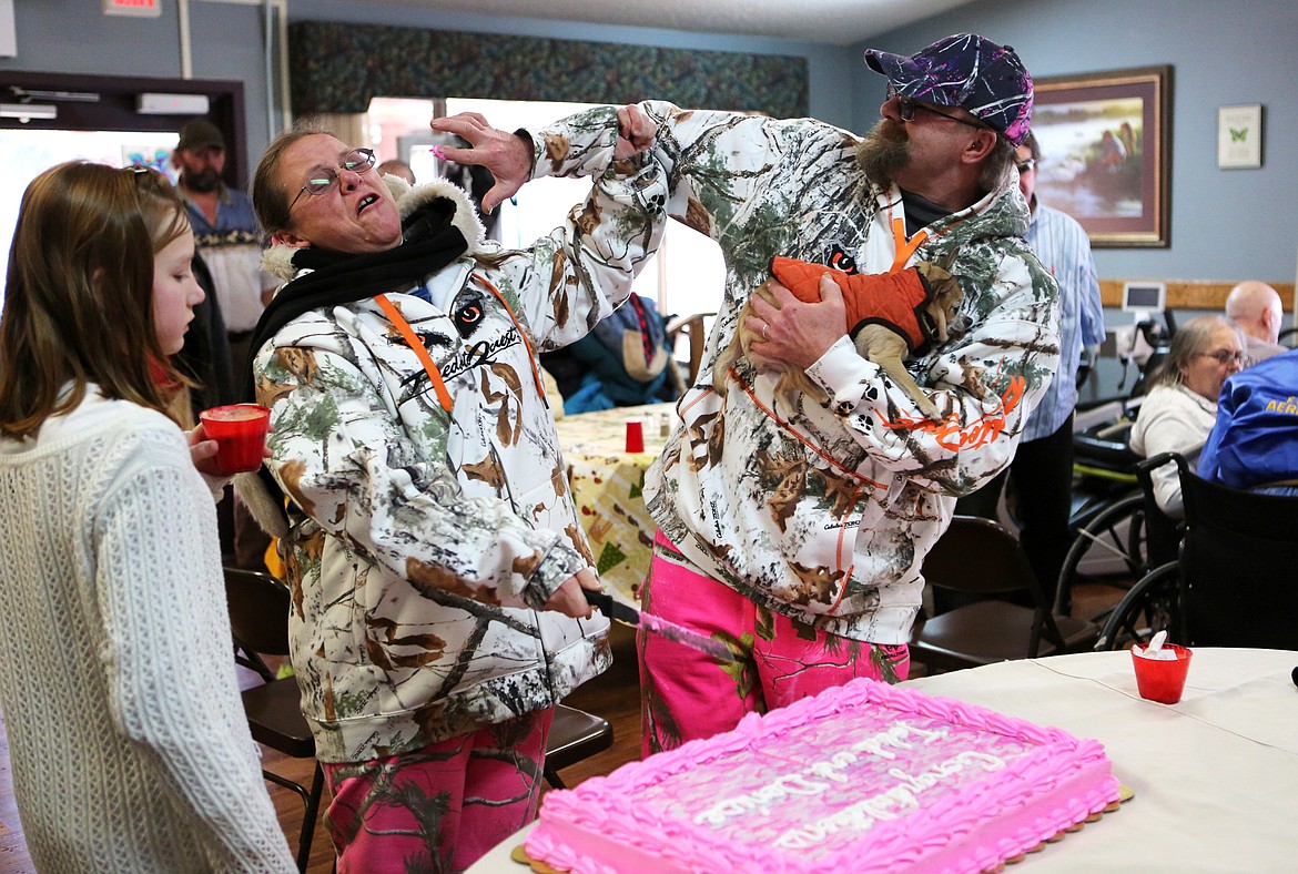 Denise Worthington-Sisco tries to dodge her new husband, Todd Worthington-Sisco, as he tries to smear frosting on her face during the cake cutting shortly after their wedding ceremony Sunday. (Mackenzie Reiss/Daily Inter Lake)