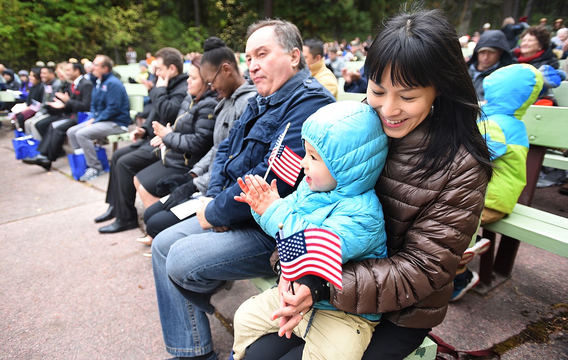 Yum Ueki of Japan holds her son Luka Trilisky during a naturalization ceremony at Glacier National Park where 10 new citizens made their Oath of Allegiance to their adopted country. This is the second year a naturalization ceremony has been held at the amphitheater overlooking Lake McDonald. The new citizens are originally from Mexico, Sweden, Chile, Brazil, the Philippines, Hati, Bulgaria and Japan.