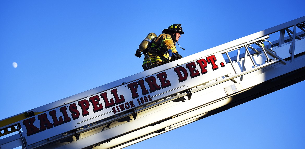 Kalispell Firefighter Jake Felts carries a tool up to firefighters dealing with the last of a fire on the roof of the old hospital building in Kalispell. The roof fire was responded to by Kalispell,&#160;Evergreen Fire and Rescue, South Kalispell, and Smith Valley departments. Kalispell Police and the Flathead County Sheriff&#146;s Office were also on scene.